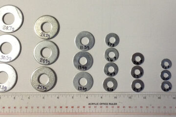 Example weights made from washers, with each washer's mass written on it in marker, showing the variation that can be expected for a given size of washer
